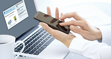 (c) LDprod/Shutterstock.com Ein Herr mit Smartphone in der Hand vor einem geöffneten Laptop.